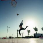 Silhouette of a basketball player jumping for a dunk at sunrise in Progreso, Mexico.