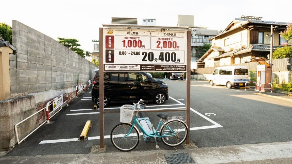 A bicycle parked in an empty parking lot in Kyoto, Japan, with traditional architecture in the background.