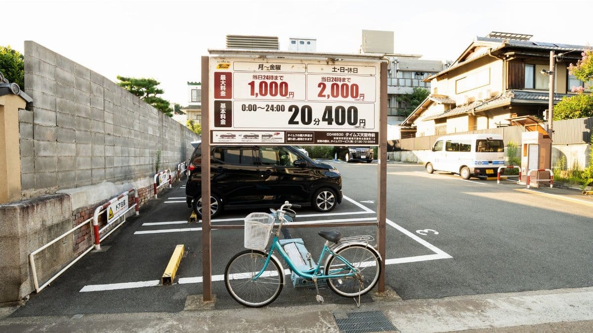 A bicycle parked in an empty parking lot in Kyoto, Japan, with traditional architecture in the background.