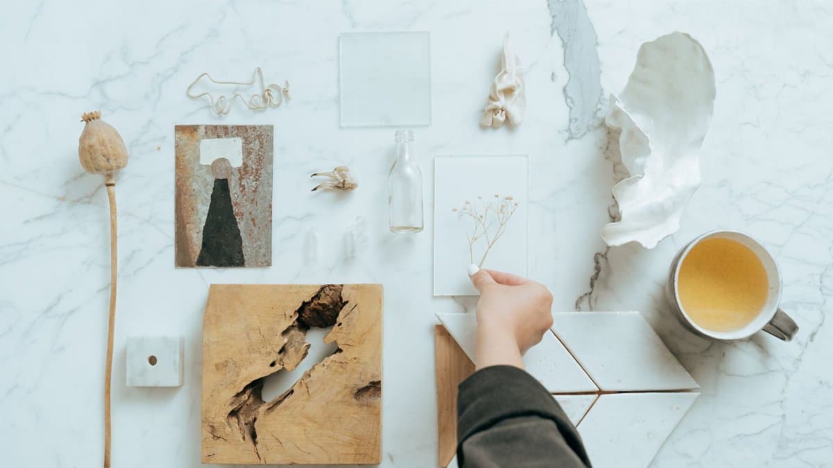 Top view of assorted artistic objects arranged on a marble surface, featuring natural textures and a minimalist style.