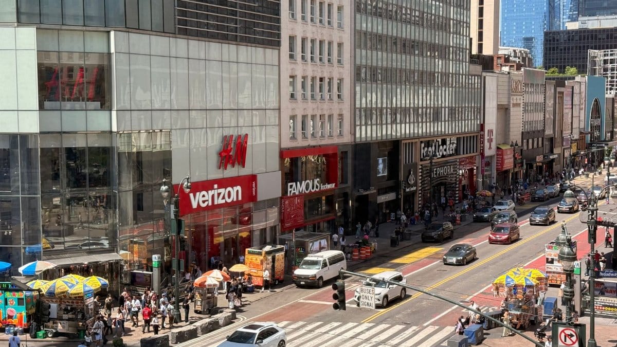 Busy day in Midtown Manhattan with pedestrians and traffic on a sunny afternoon.