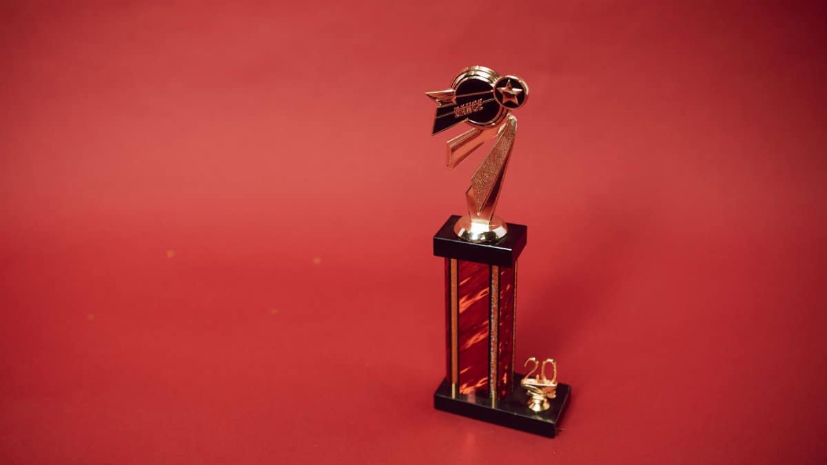 Golden trophy standing on a vibrant red background, symbolizing success and achievement.