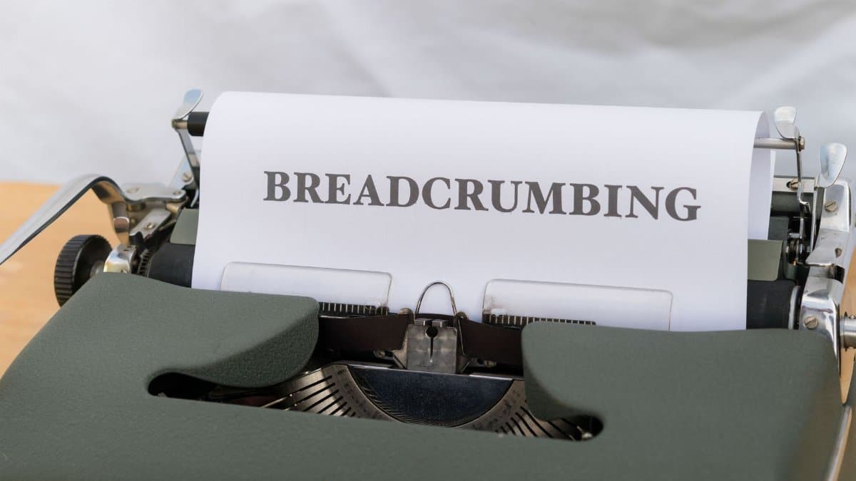 Close-up of a vintage typewriter with paper displaying the word 'BREADCRUMBING'.