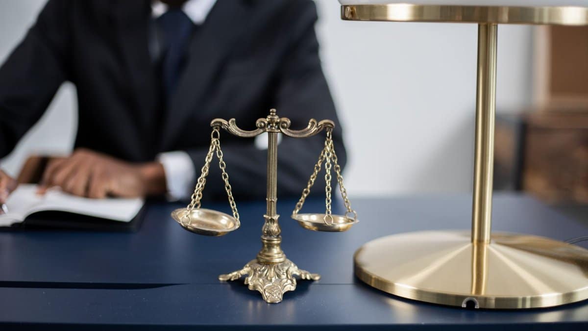 Elegant legal office with a close-up of golden scales of justice on a sleek dark desk.
