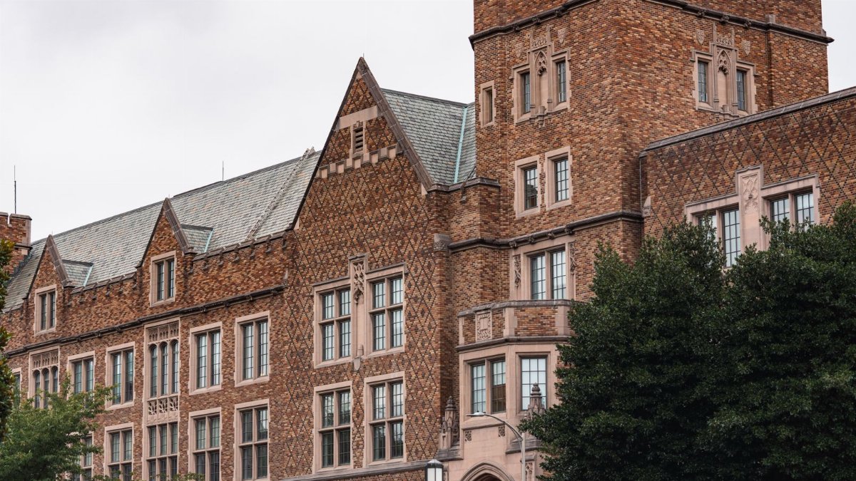 Majestic brick university building with lush greenery. Classic architectural design showcasing large windows.