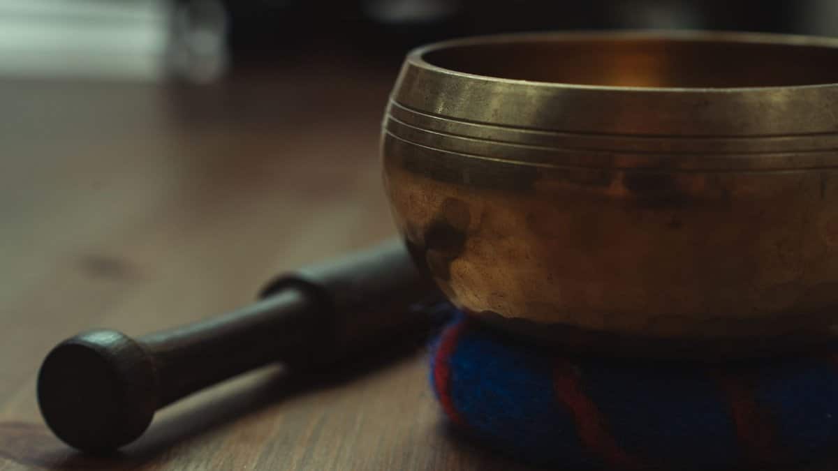 Close-up of a Tibetan singing bowl on a wooden table, ideal for sound therapy and relaxation.