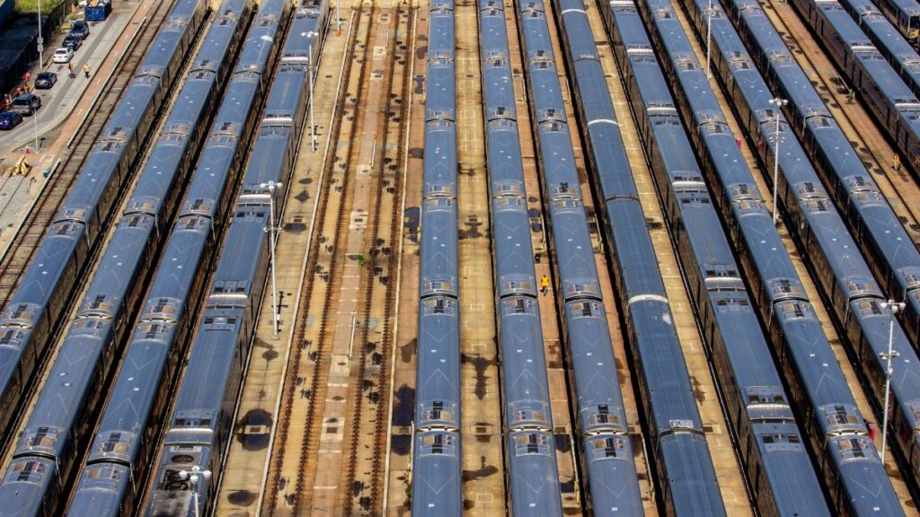 Aerial view of a busy train yard in New York City showcasing multiple trains parked in parallel tracks.