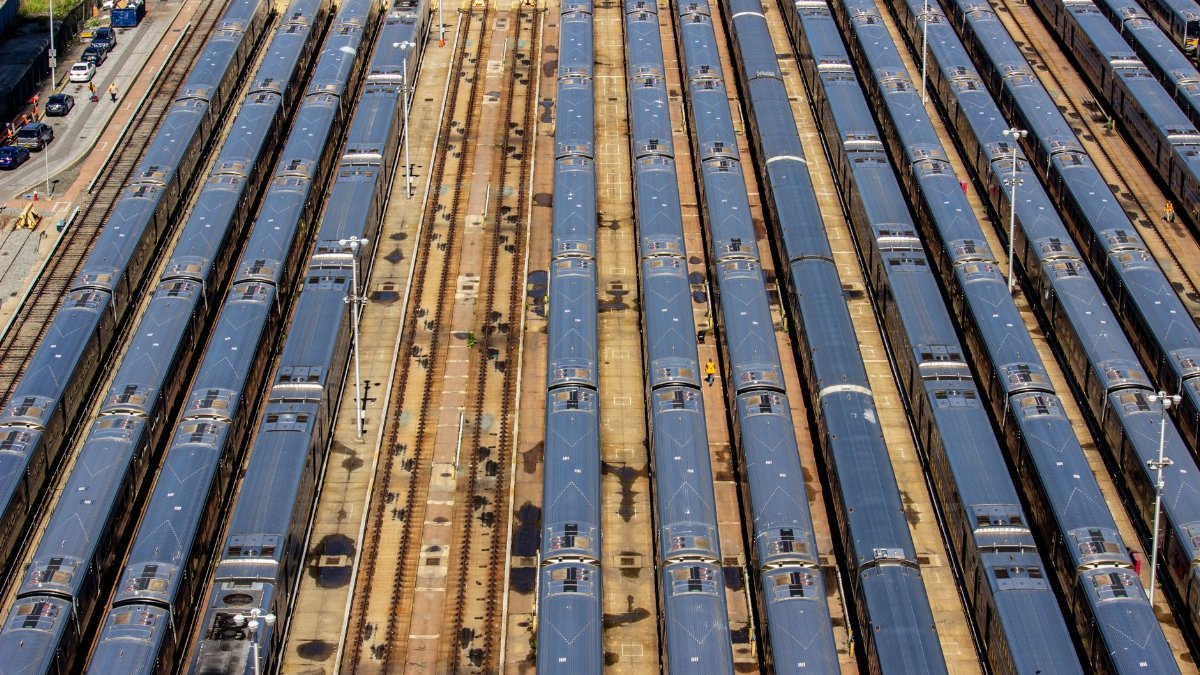 Aerial view of a busy train yard in New York City showcasing multiple trains parked in parallel tracks.