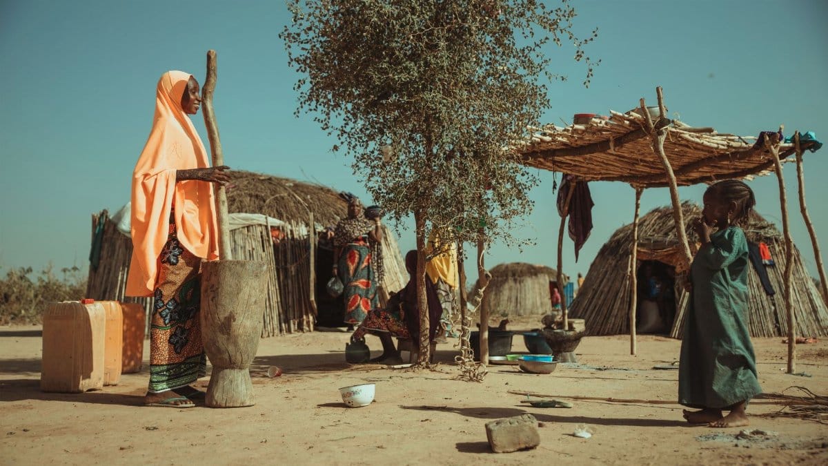 A vibrant scene depicting daily life in an African tribal village with traditional huts and local people.