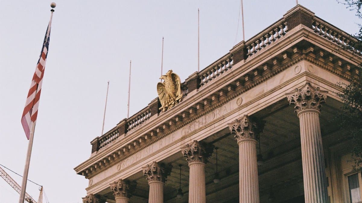 Neoclassical building facade with columns, American flag, and eagle crest in Dallas, Texas.