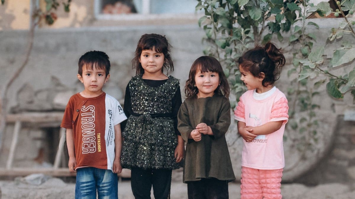 Four children standing outdoors in casual clothing, showcasing friendship and joy.