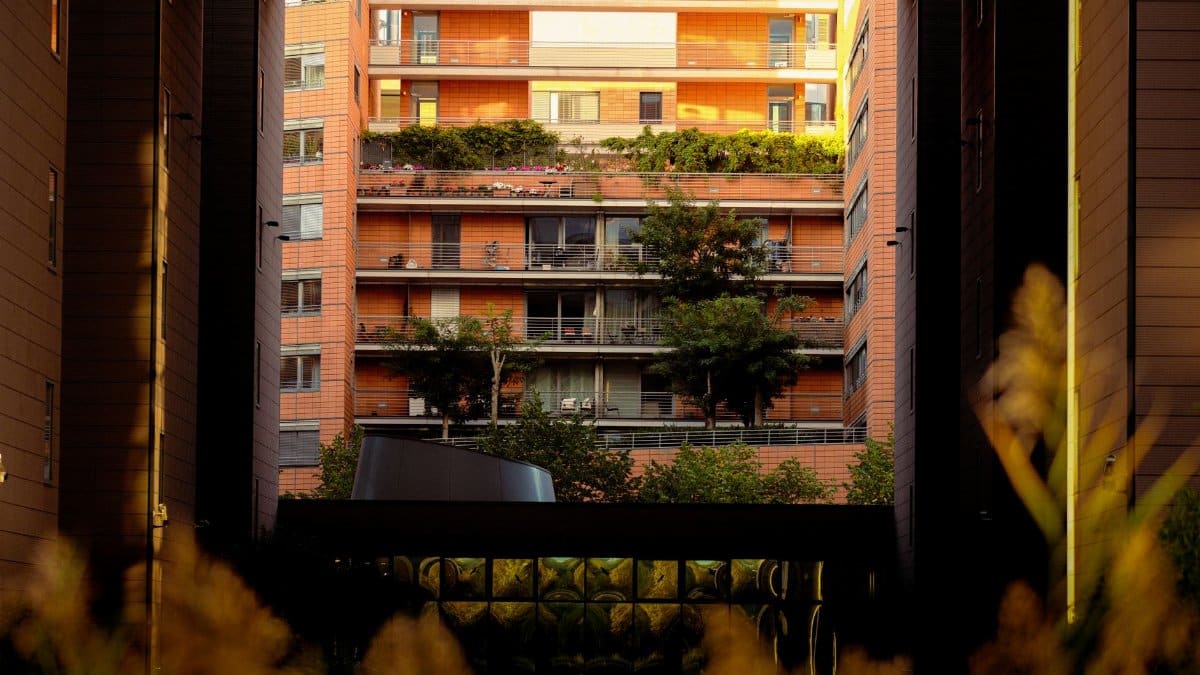 Urban apartment complex with modern design and greenery at sunset.