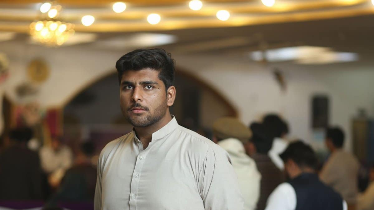 Young man in traditional attire at a social gathering in Sheikhupura, Pakistan.