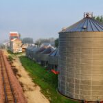 Aerial shot capturing grain silos and railroad tracks in rural Utica, Minnesota.
