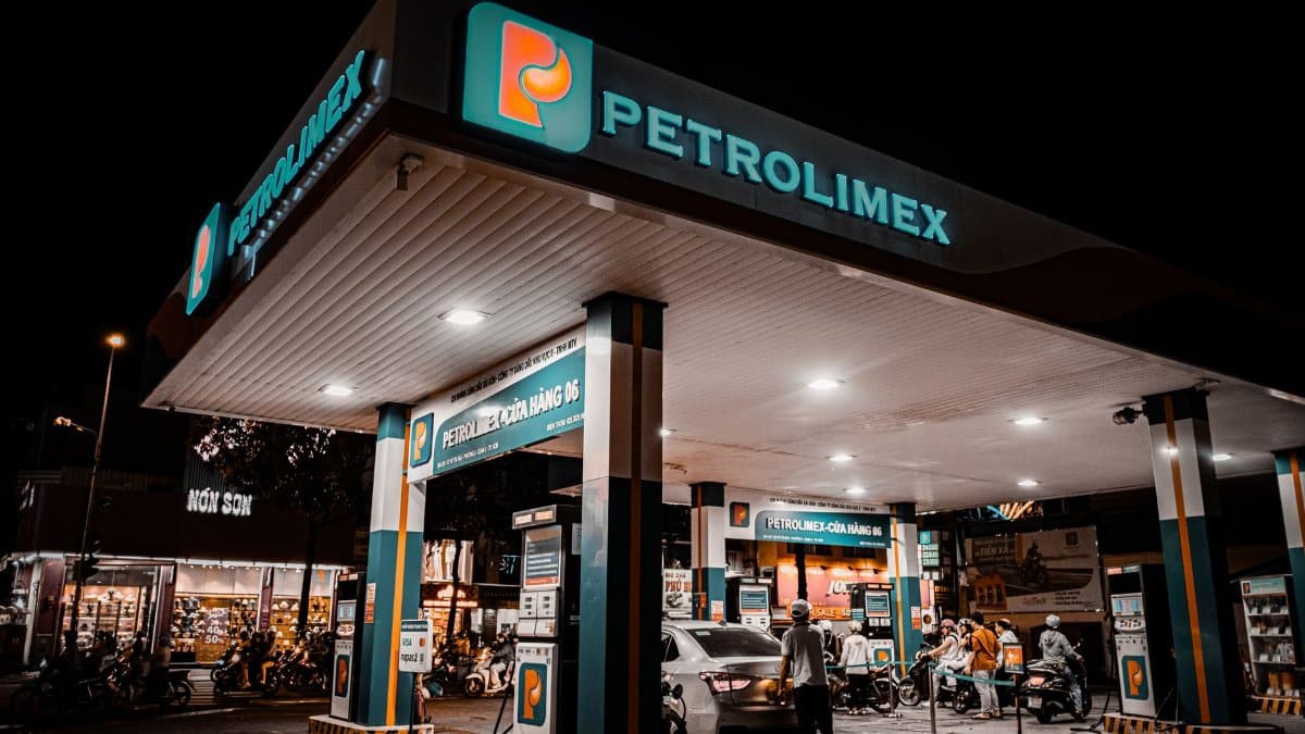 Night view of a Petrolimex gas station with customers fueling up.