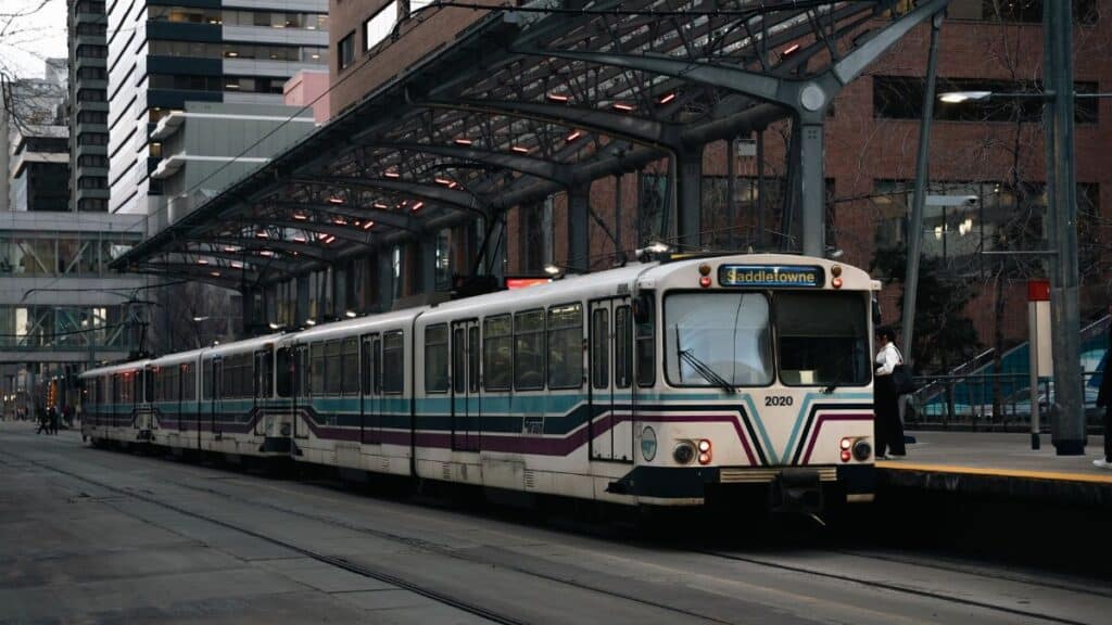 Light rail train at city station with modern urban background during the day.