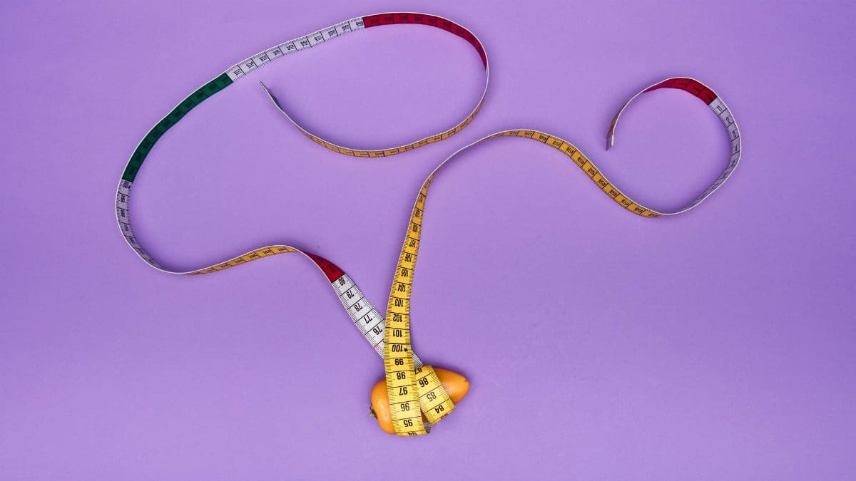 A measuring tape artistically wraps around an orange on a vivid purple background. Perfect for creative concepts.
