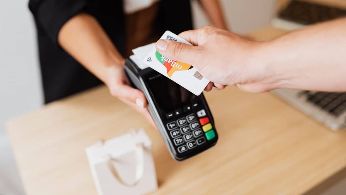 Close-up of contactless payment using a credit card at a modern POS terminal.