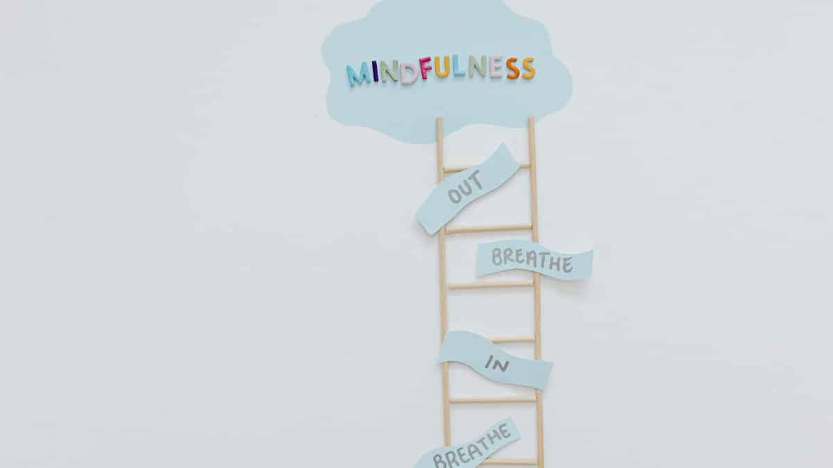 Creative mindfulness concept with ladder, words, and cloud shape for mental well-being.