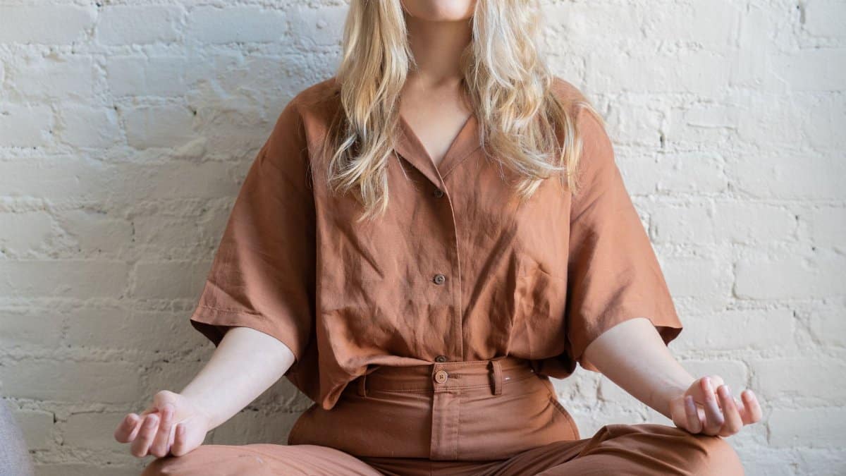 Woman meditating indoors, practicing mindfulness and relaxation techniques.