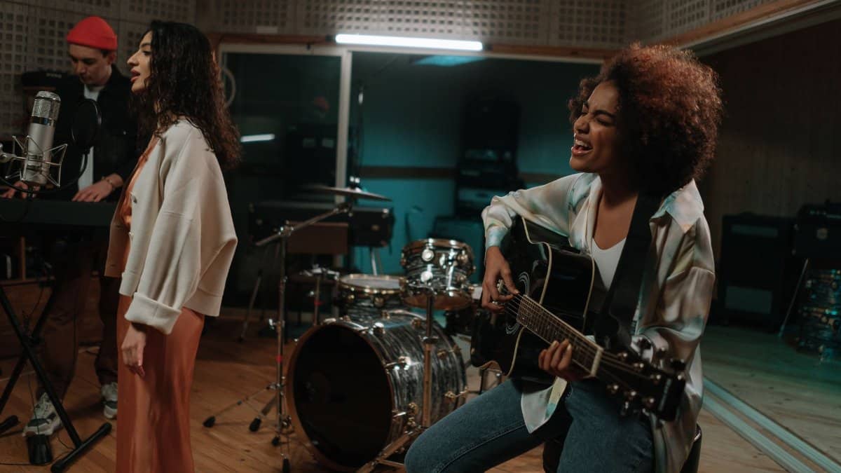 A diverse band passionately rehearsing with instruments in a modern music studio.