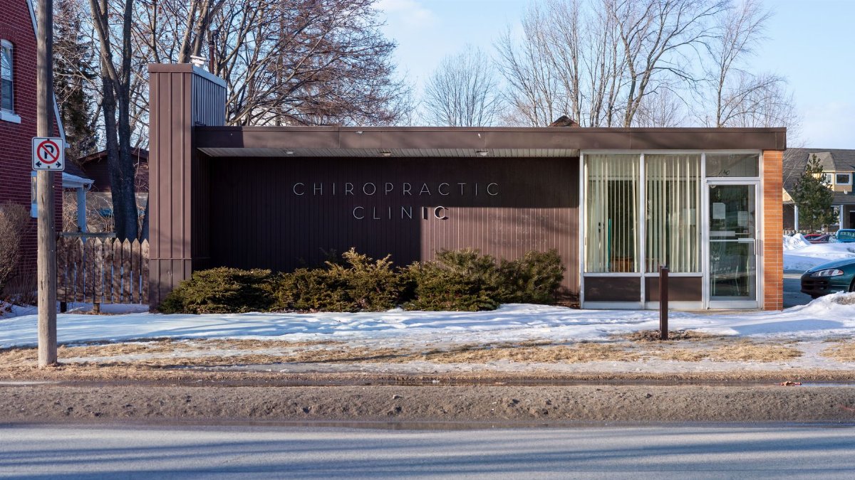 Exterior view of a modern chiropractic clinic in a snowy suburban neighborhood.