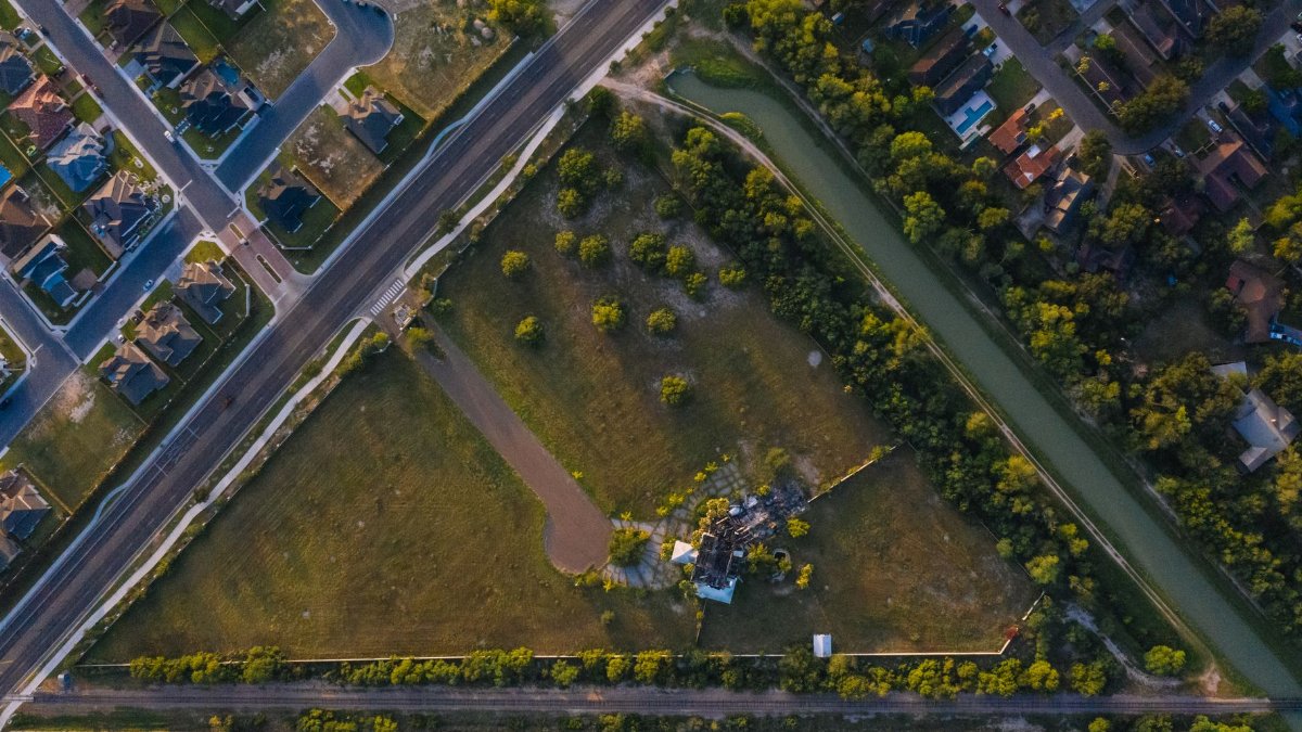 Drone shot showcasing a suburban neighborhood and green fields in Edinburg, Texas.