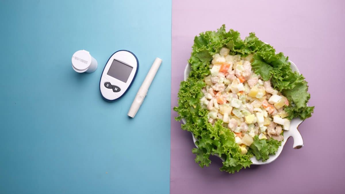 Top view of diabetes equipment and fresh salad representing healthy living.