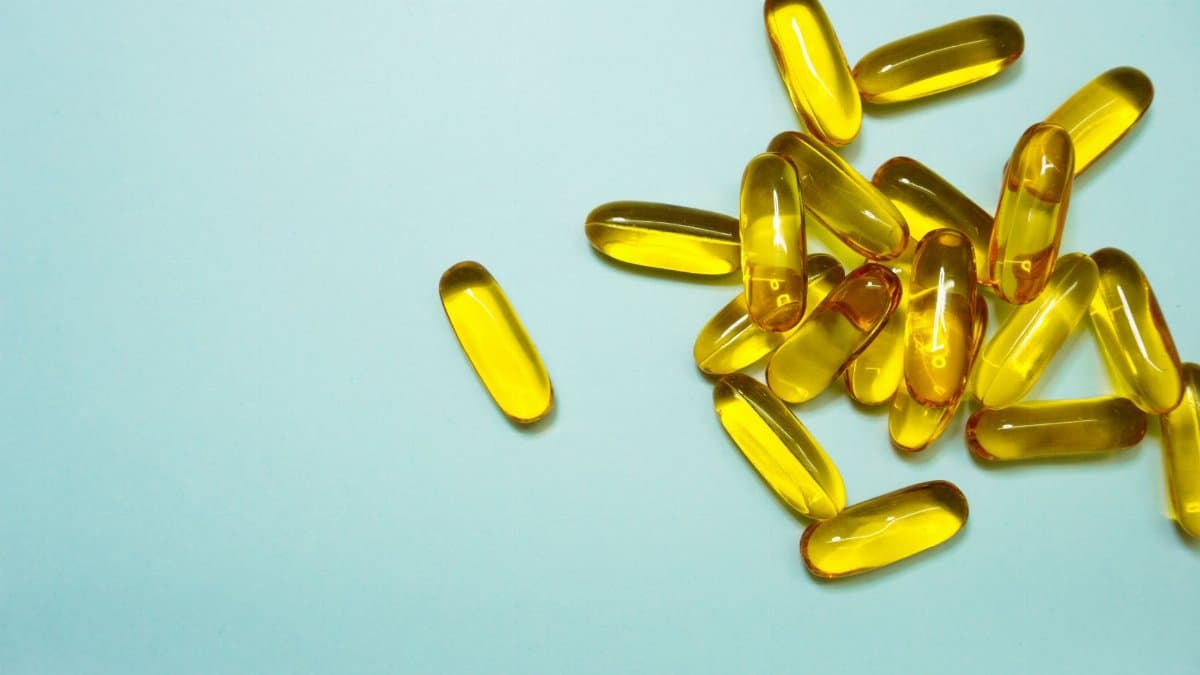A collection of omega-3 capsules on a light blue surface, ideal for health and supplement themes.