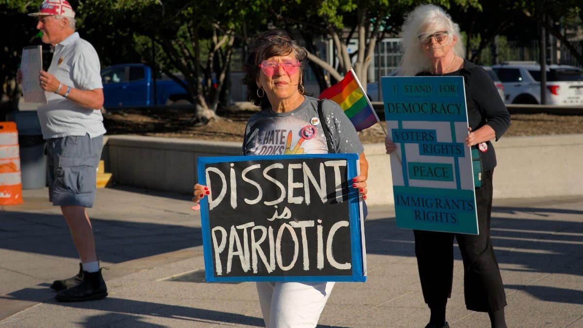 A peaceful protest in Baltimore with signs supporting democracy and immigrant rights.