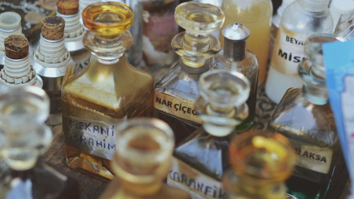 Collection of vintage glass perfume bottles with various labels in a close-up view.