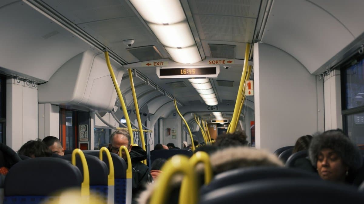 Passengers commuting inside a modern public train during the day.