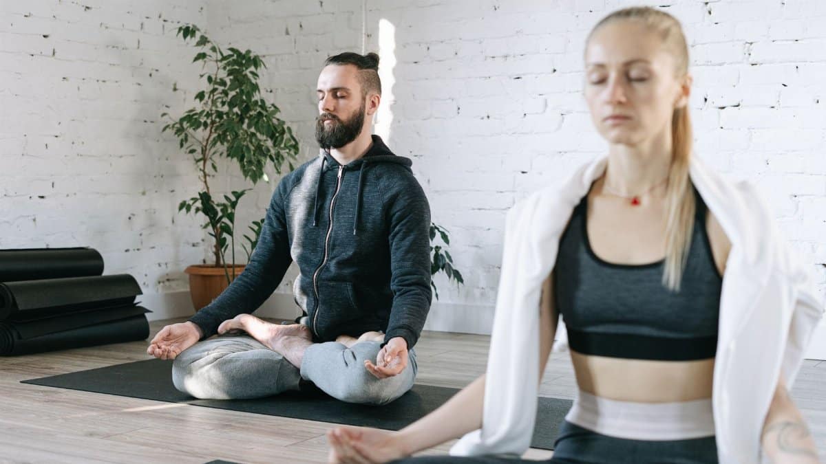 Two adults meditating in a calm, indoor setting enhancing mindfulness and wellness.