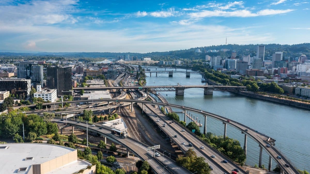 Aerial view of Portland cityscape featuring bridges over a river and urban landscapes on a clear day.