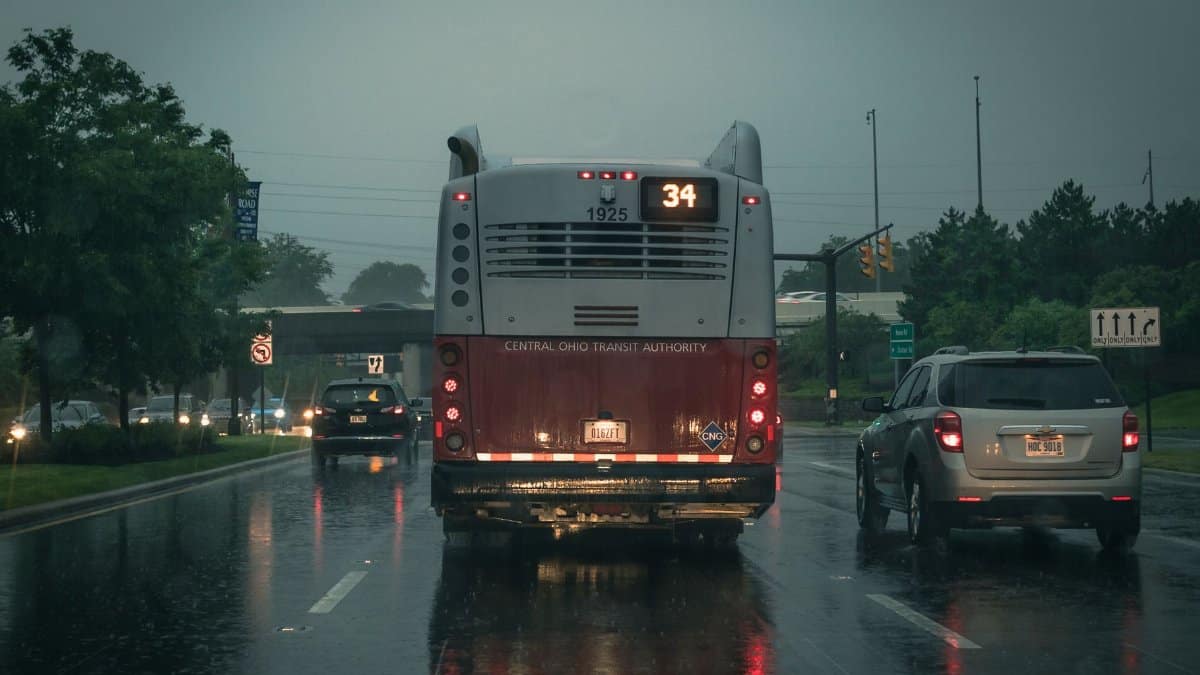 Traffic on a rainy day featuring the Central Ohio Transit Authority bus and cars on a wet street.