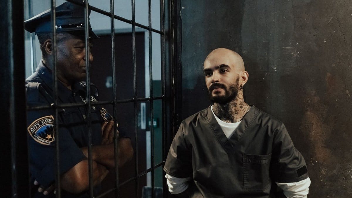 A tense encounter between a police officer and a prisoner inside a jail cell.