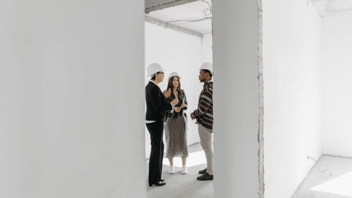 Group discussing potential property purchase inside an unfinished building.