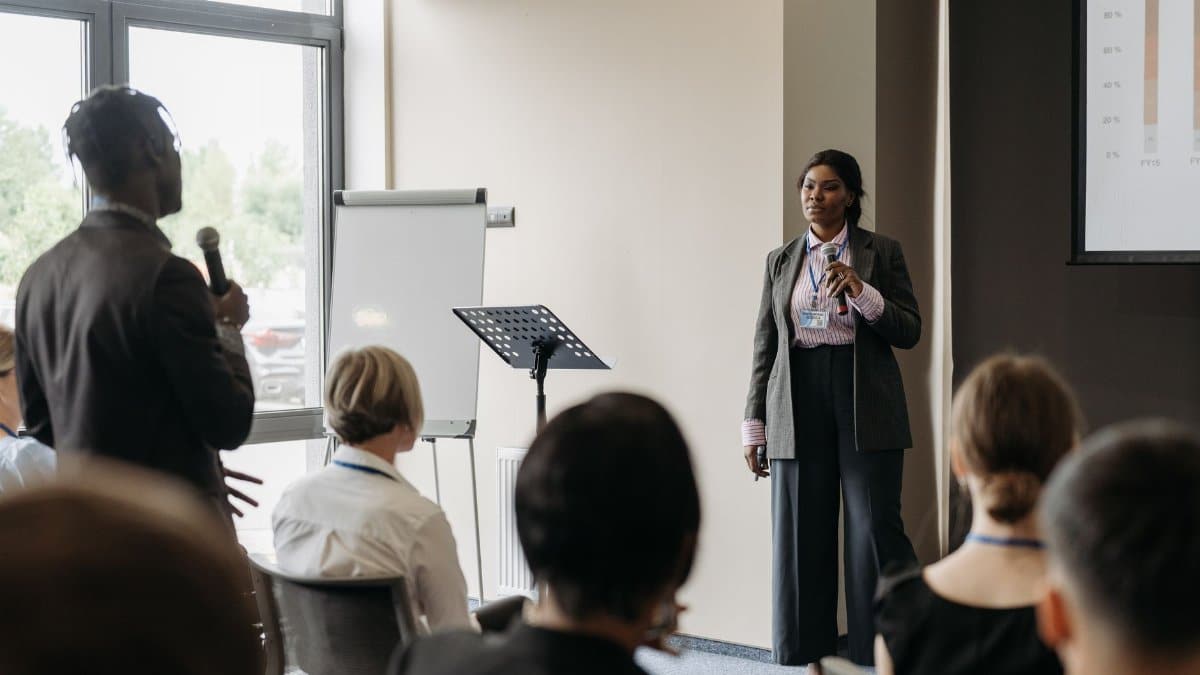 Professional business conference presentation with diverse participants engaging in communication.