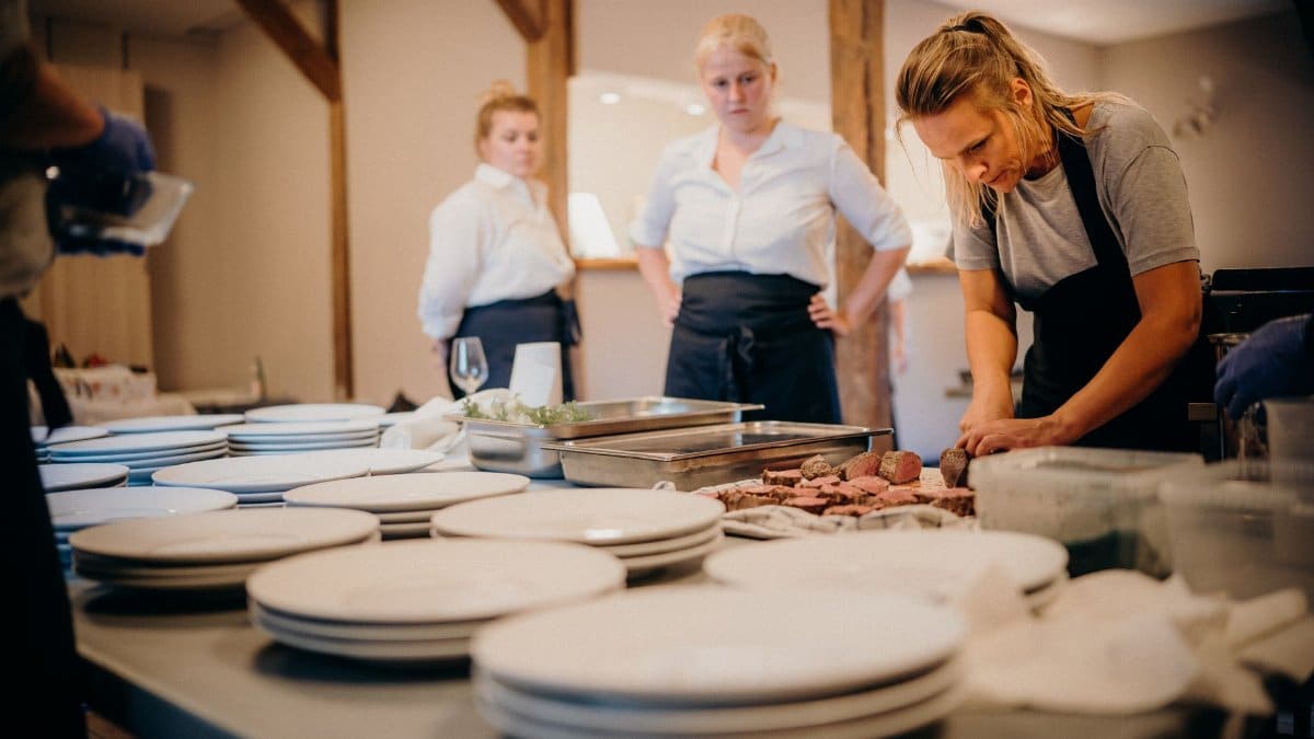 Chefs working together in a restaurant kitchen, preparing gourmet dishes for upcoming service.