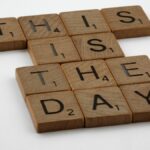 Scrabble tiles spell 'This is the Day' on a white background, inspiring change.
