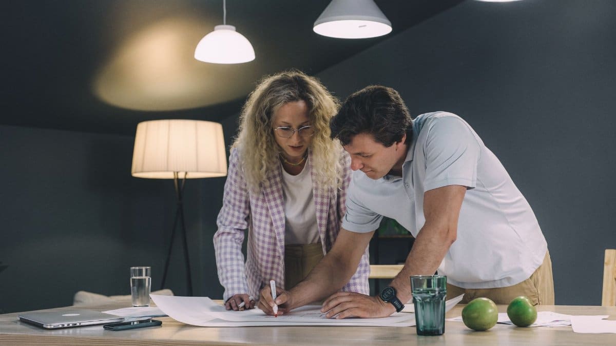 Two professionals collaborating over a project in a modern office setting.