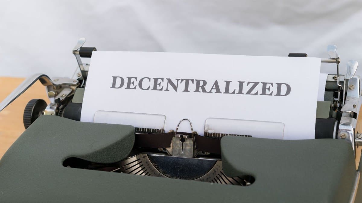 Close-up of a vintage typewriter with paper showing the word 'Decentralized'.