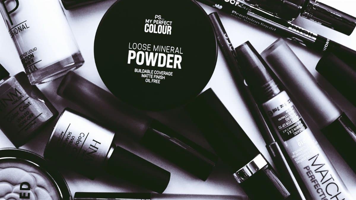 Elegant monochrome flatlay showcasing a collection of beauty products and cosmetics.