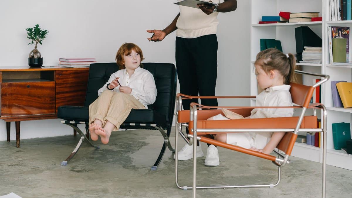 Children engaging in a therapy session with therapist in a modern office.