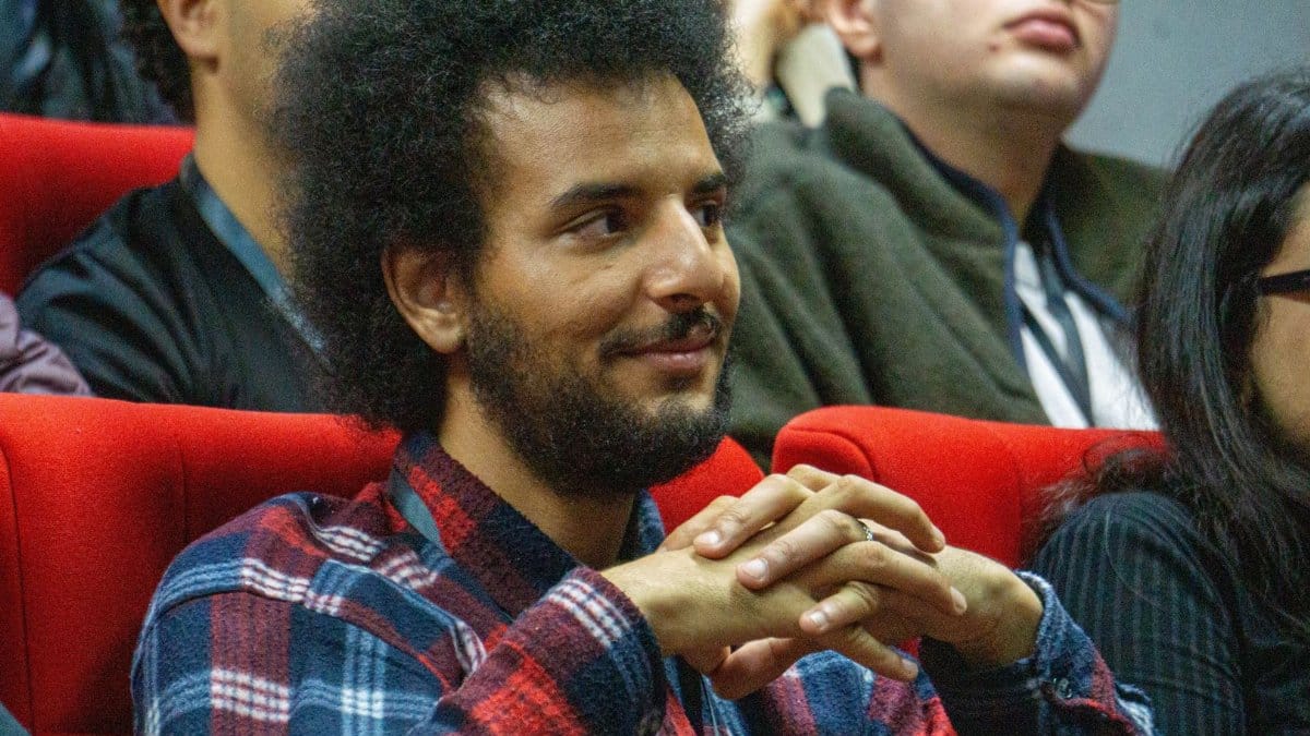 Attentive individual in a lecture hall setting, showing interest in the presentation.