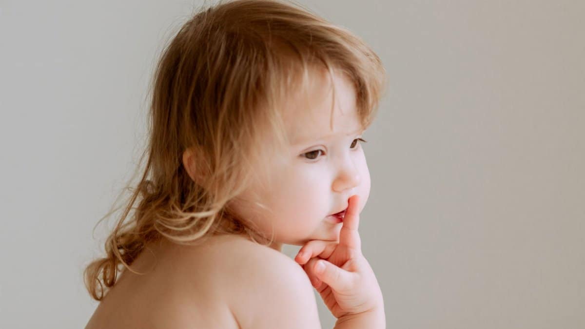 Captivating portrait of a toddler in deep thought, exuding innocence and curiosity.