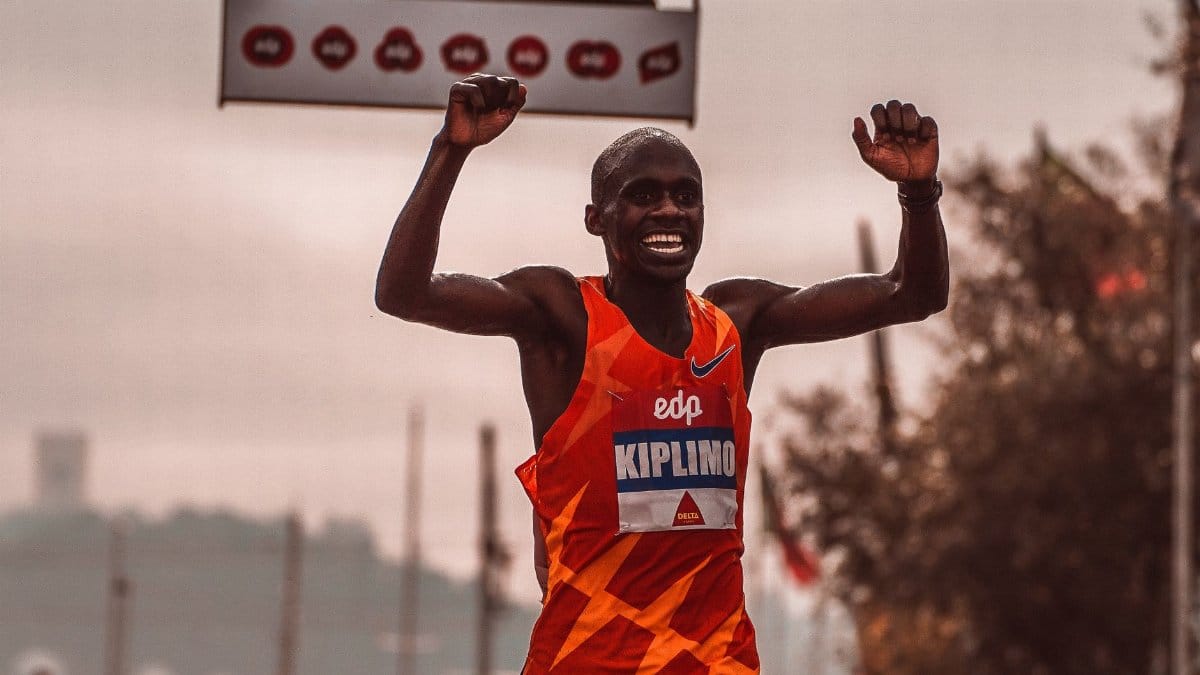 An athlete joyfully celebrates crossing the marathon finish line, exemplifying victory and determination.