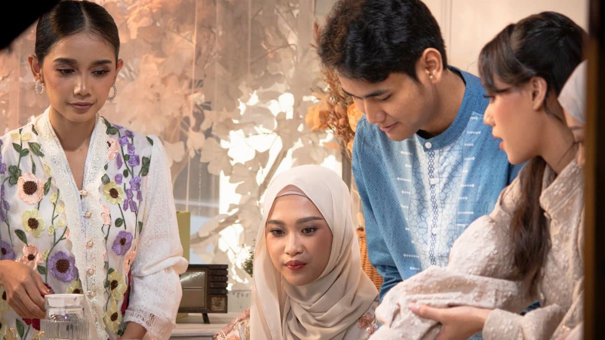 Young adults in Indonesia celebrating Eid indoors, sharing moments in traditional attire.