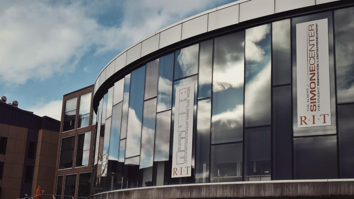Modern urban building showcasing contemporary architecture with reflections of the sky in its glass facade.