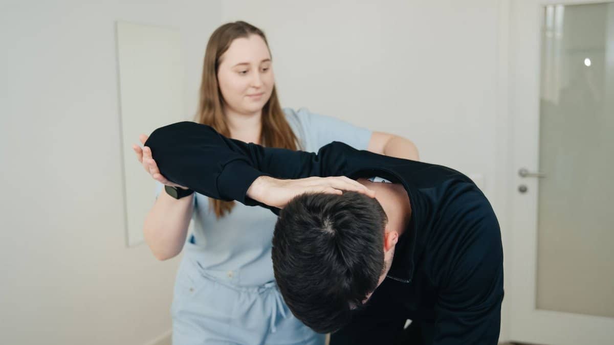 A physiotherapist aids a patient in a stretching exercise for rehabilitation.